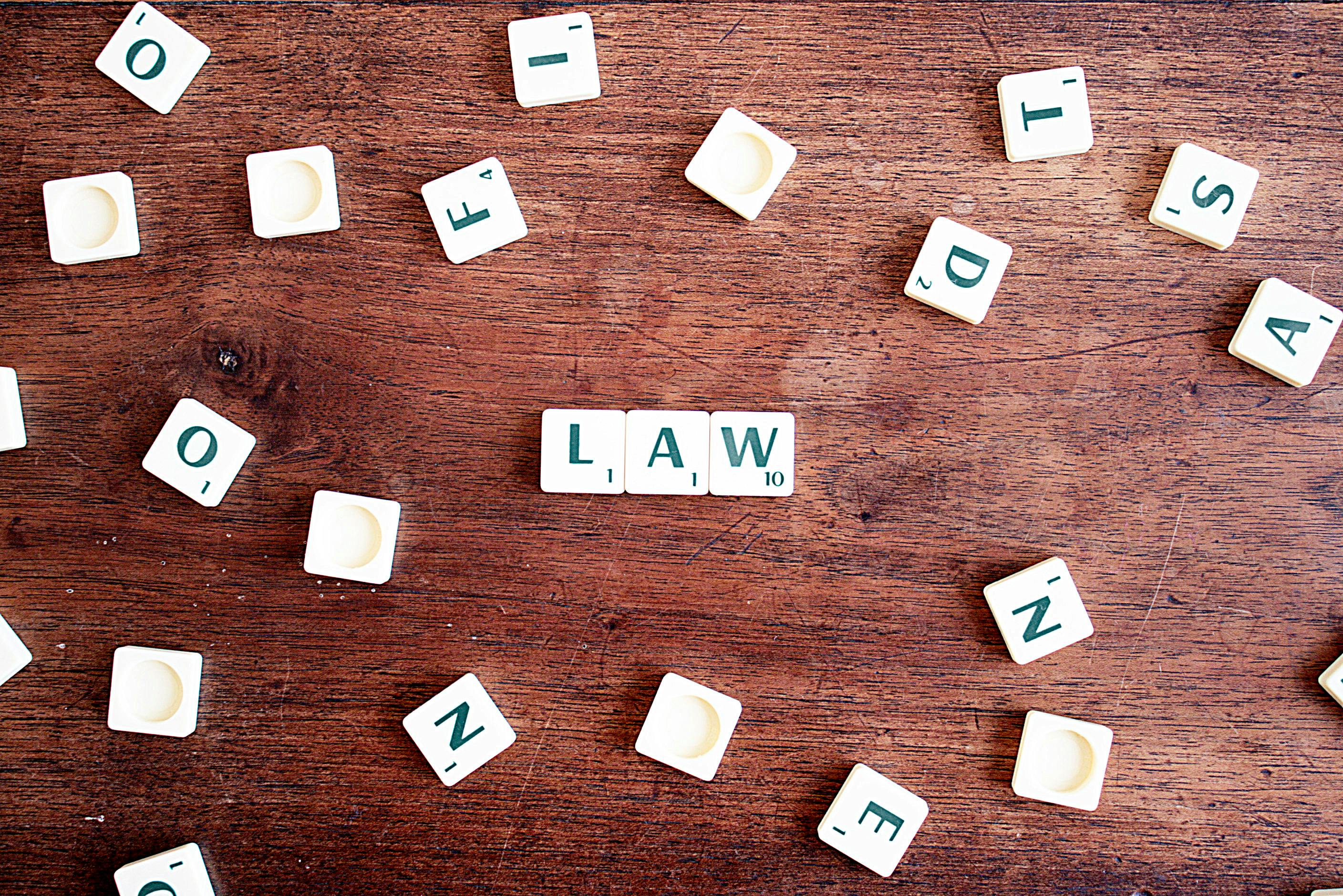 Scrabble tiles that spell out the word “law”